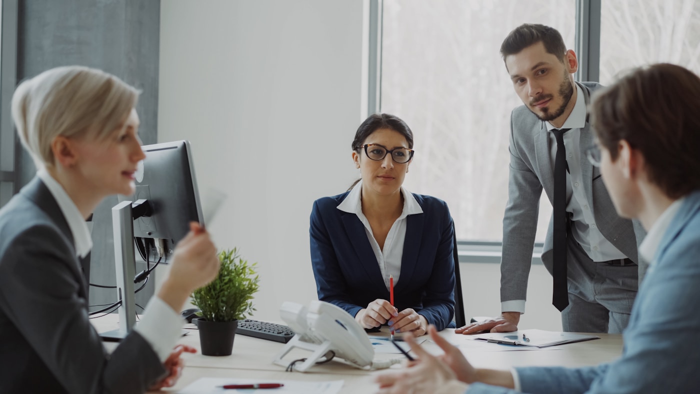 Business professionals discussing employee benefits in a modern office